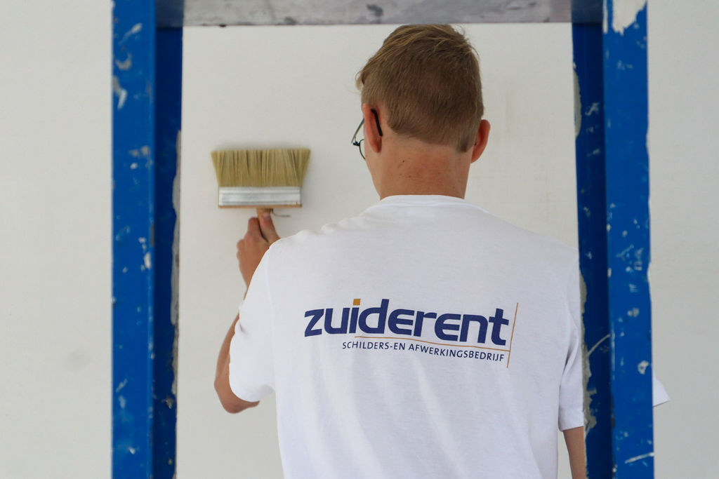 Zuiderent schilder betrokken bij de voorbereiding en het schilderen van een binnenmuur.