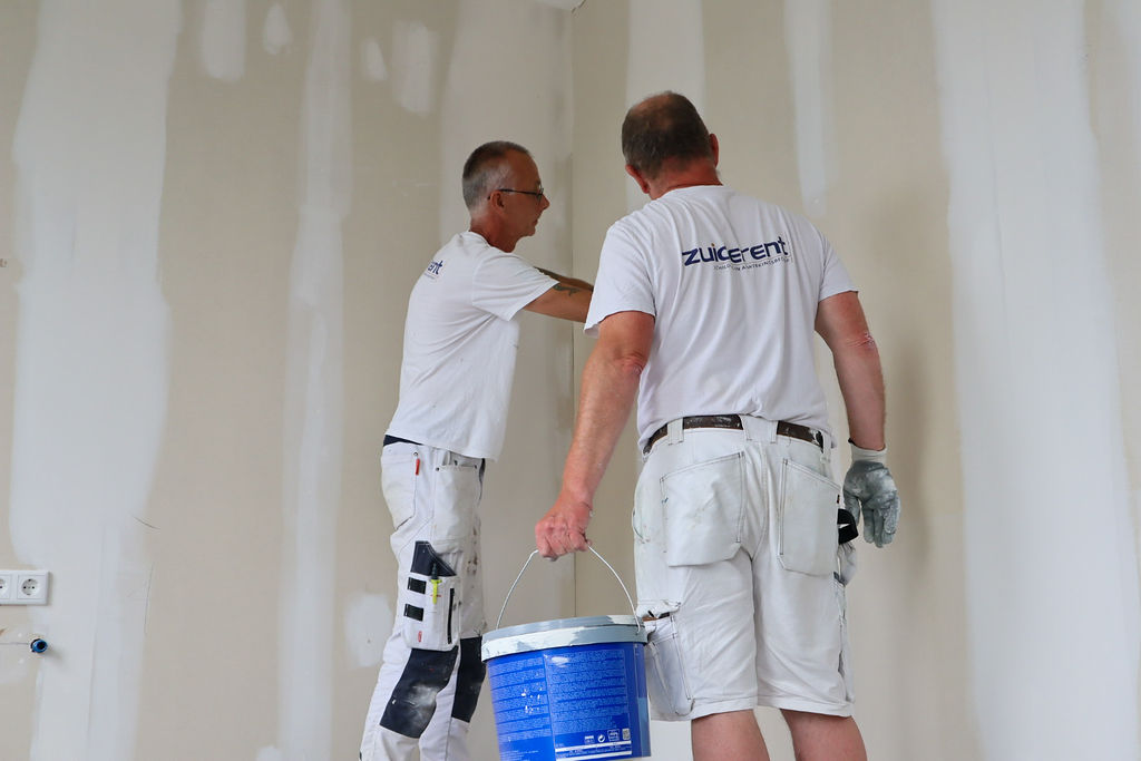 Twee schilders van Zuiderent werken samen aan een binnenmuur