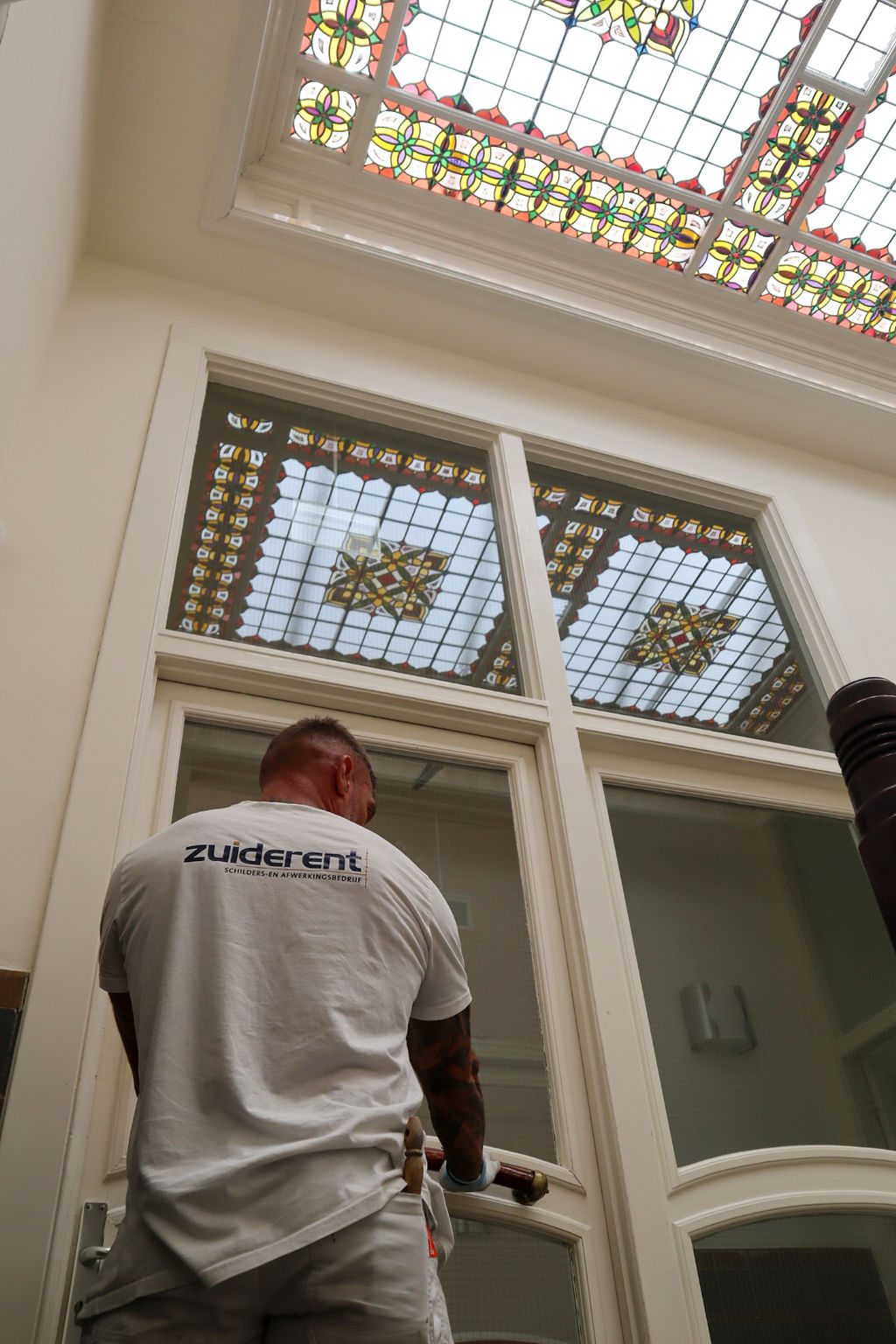 Zuiderent medewerker deur van mooi gebouw binnen schilderen.